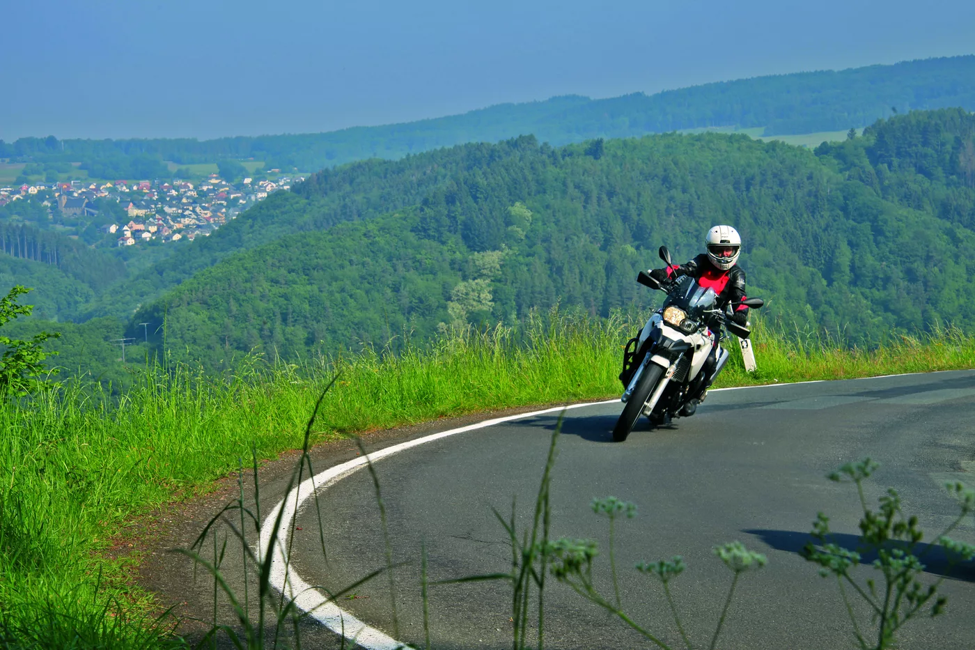 Motorrad in einer Kurve mit weitem Blick ins Tal