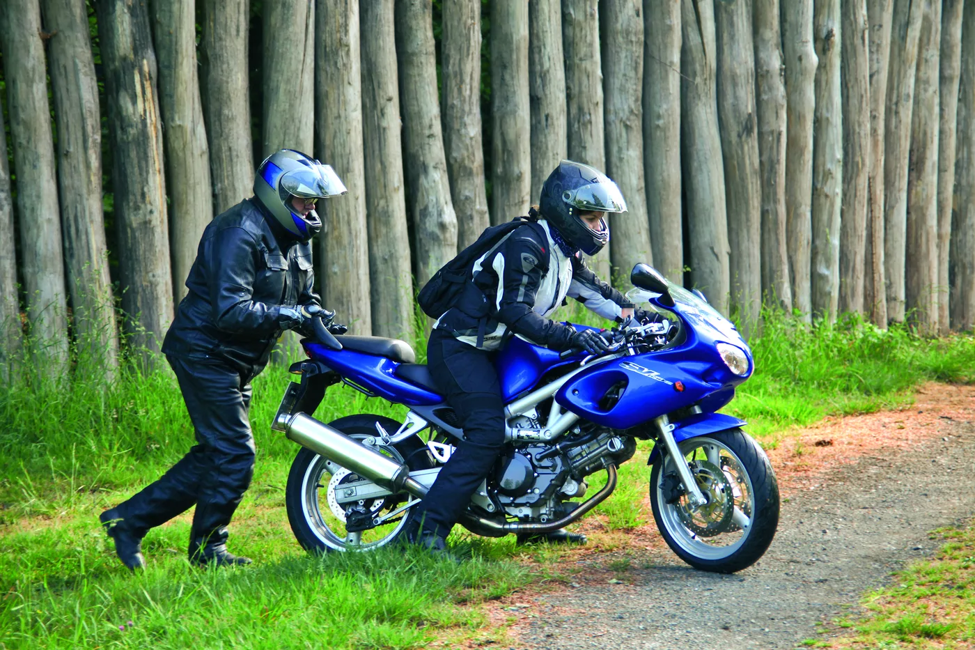 Rekonstruierte Holzpalisade des Limes, davor ein Motorrad